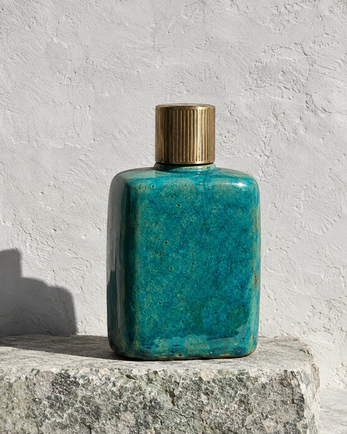 Isis flacon in turquoise faience glaze on a grey-green granite block