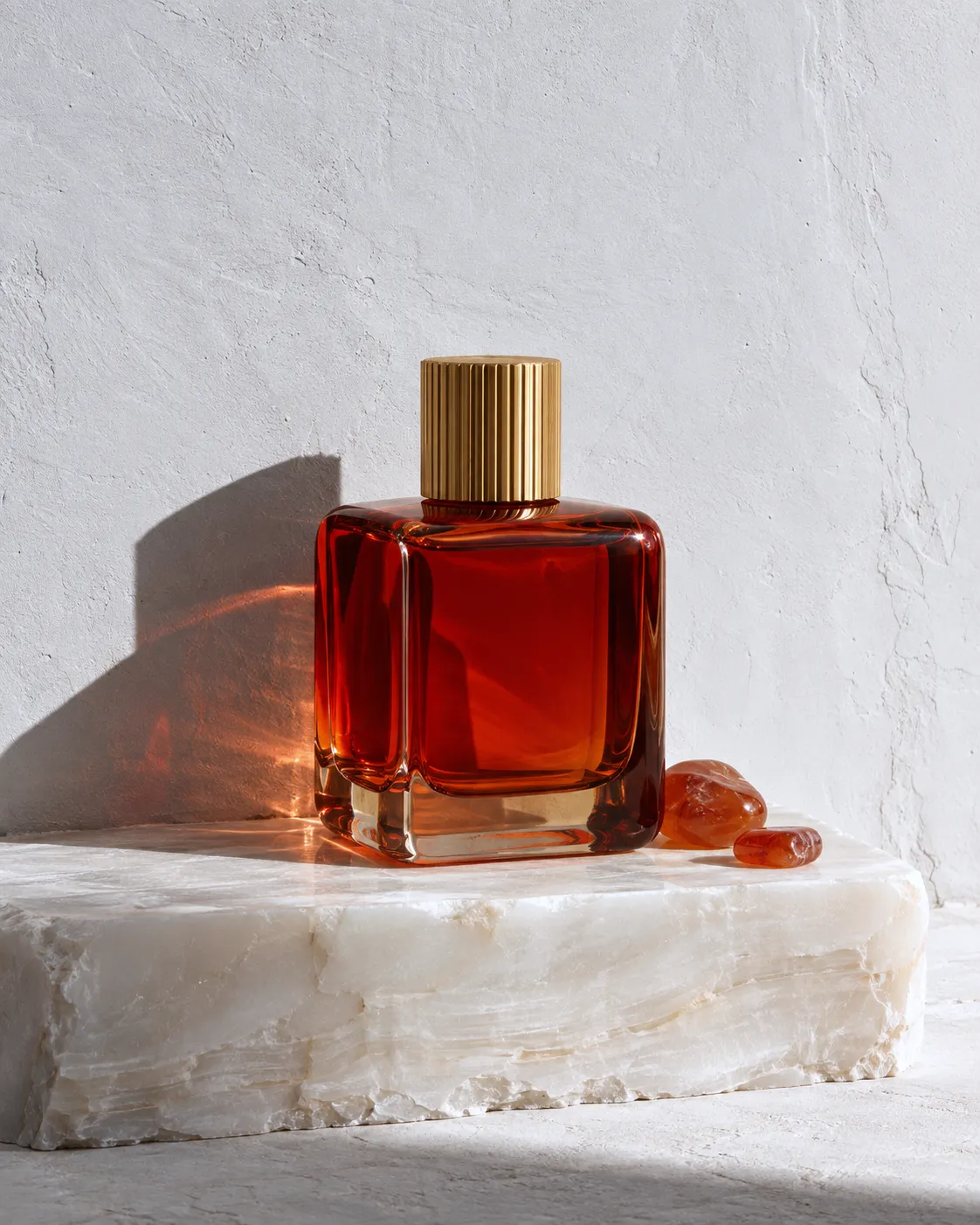 Ra flacon in translucent carnelian glass on white alabaster, red light in its shadow